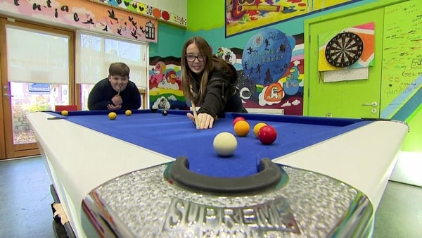 Two young people playing pool at a Youth Club.