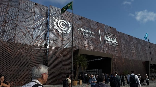 Attendees walk in front of the main entrance to the COP30 UN Climate Change Conference in Belem