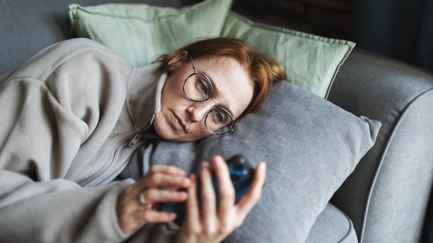 Mia adult woman lying in bed with mobile, sad and depressed, bad news