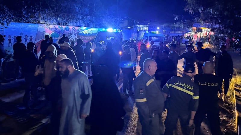 Civil defence members gather at the entrance of Ain al-Hilweh Palestinian refugee camp following the strike