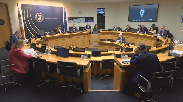 People sit around a circular desk with multiple chairs