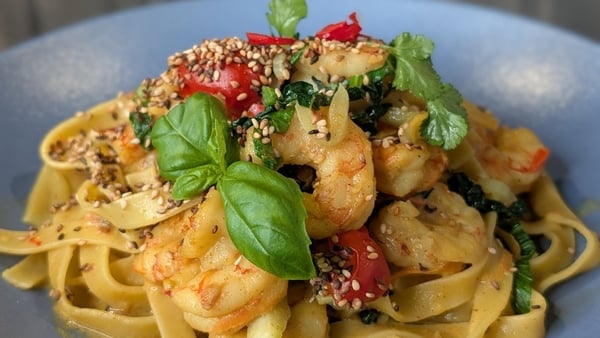 A bowl of prawn pasta with herbs on top