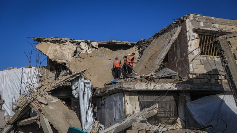 Civil defence teams inspect the rubble of a severely damaged house after its roof collapsed in the Gaza Port area of western Gaza City