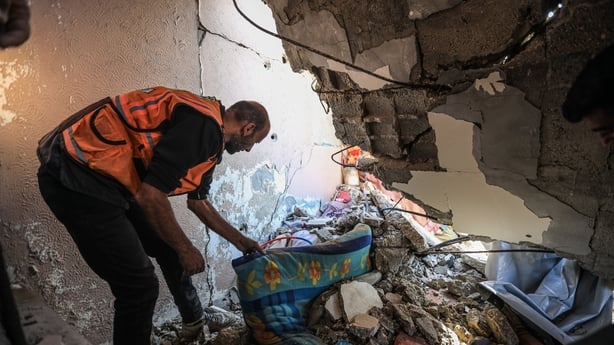 Civil defense teams inspect the rubble of a severely damaged house after its roof collapsed in the Gaza Port area of western Gaza City