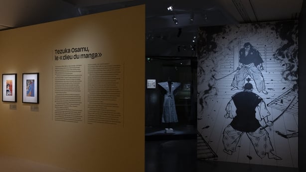 This photograph shows a a part of the room dedicated to Japanese manga artist Osamu Tezuka (L) and the reproduction of a drawing by Japanese manga artist Hiroshi Hirata (R), seen during a press visit to the exhibition Manga, tout un art! at the Guimet Museum in Paris, on 18 November, 2025