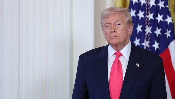 Donald Trump standing in front of an American flag
