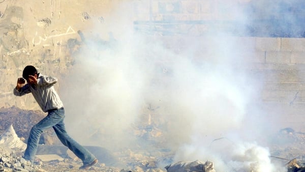 A Palestinian boy flees a tear gas shot by Israeli soldiers during clashes at the Balata refugee camp in the West Bank town of Nablus,
