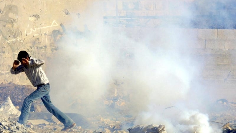 A Palestinian boy flees a tear gas shot by Israeli soldiers during clashes at the Balata refugee camp in Nablus in January