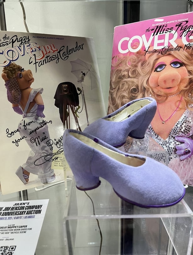The Miss Piggy-signed Cover Girl fantasy calendar 1981 and a pair of her production-worn shoes for the Couldn't We Ride bicycle scene from The Great Muppet Caper are displayed during a preview of the Jim Henson Company anniversary auction at Julien's Auctions warehouse in Gardena, California