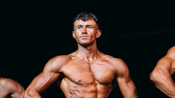 Photo shows body builder Dylan Moran strike a pose on stage at championships