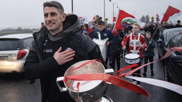 Paul Geaney leading the Scoil Iognaid Band and players over Blennerville Bridge 