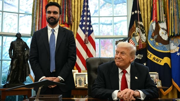 US President Donald Trump sits at a desk