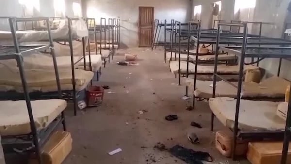 A picture of a ransacked room with a number of bunk beds on either side