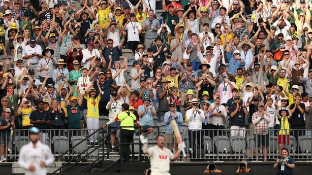 Fans congratulate Travis Head of Australia as he leaves the field after being dismissed for 123 runs by Brydon Carse of England during day two of the First 2025/26 Ashes Series Test Match between Australia and England at Perth Stadium on November 22, 2025 in Perth, Australia. 