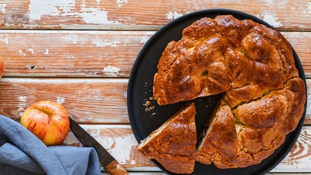 Overhead view of apple pie in plate on rural wooden table