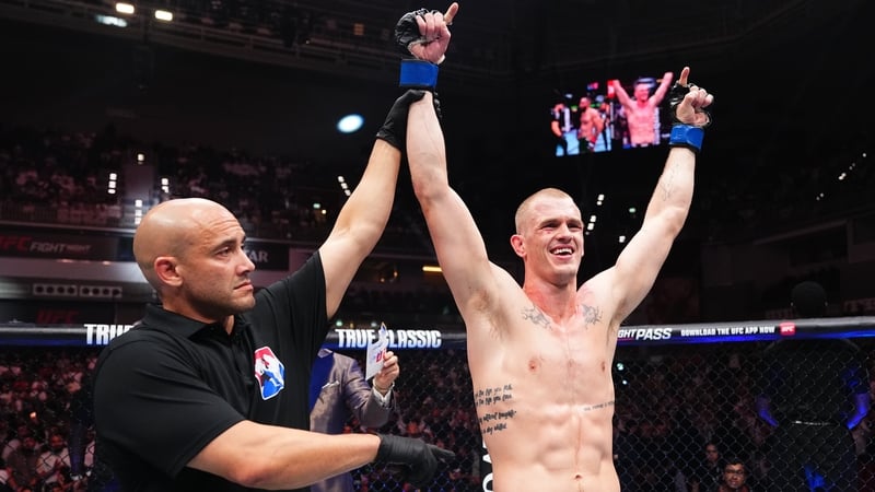 Ian 'Machado' Garry (R) has his arm raised in victory