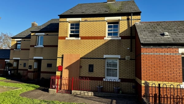 Image of house with boarded up front door