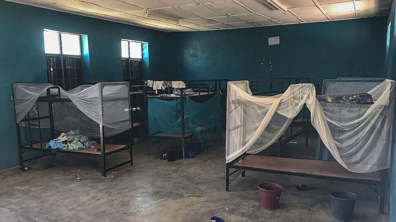 Empty bunk beds and scattered belongings inside a student dormitory at St Mary's Catholic School in Papiri