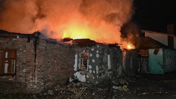 Fire burns at a house that was destroyed in a Russian drone strike in Kharkiv