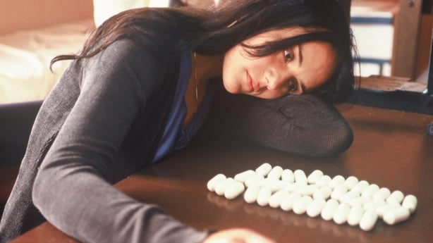 Maria (Catalina Sandino Moreno) looks at the drugs she has to ingest in Maria Full of Grace