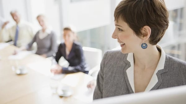 A woman speaks to a board meeting