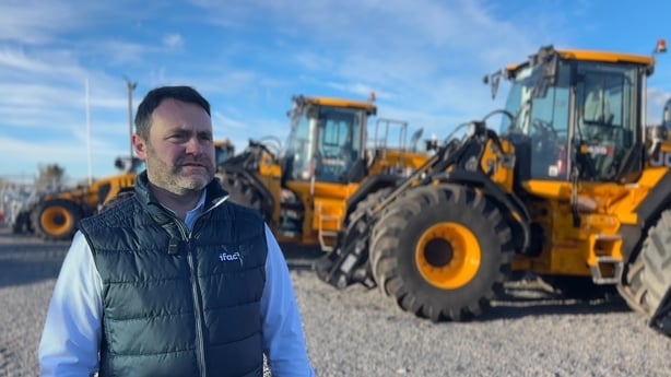 A man standing in front of a tractor