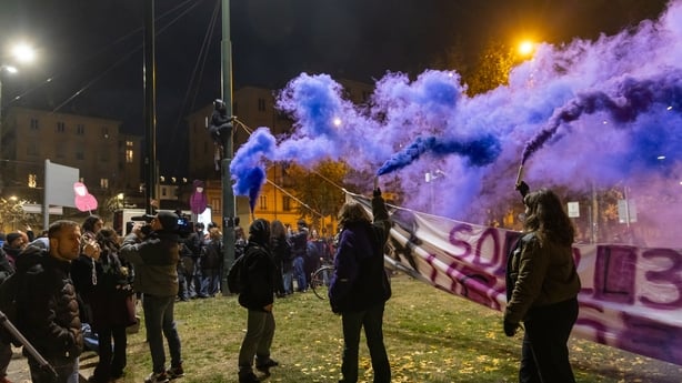 Women hold flares during a protest in Turin, Italy