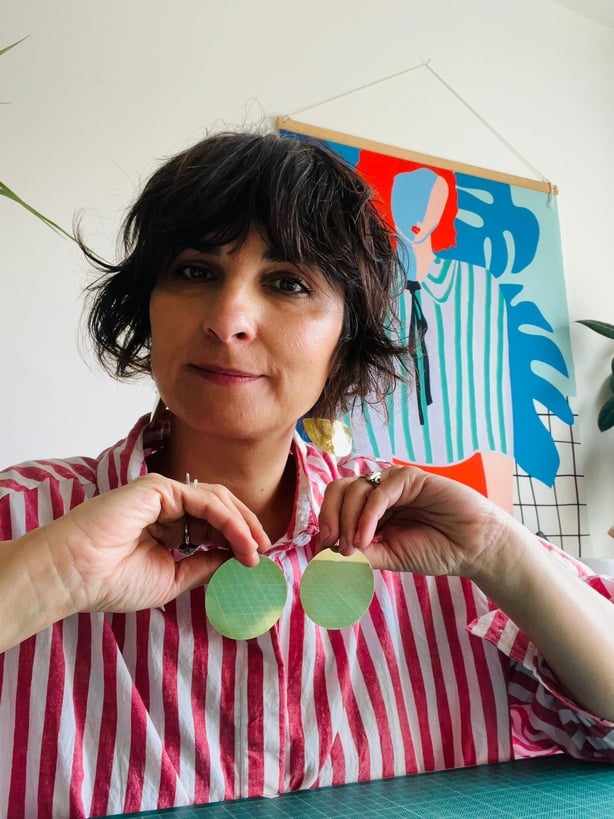 Jewellery designer Daki Zdravka Rezic in her studio holding a pair of earrings