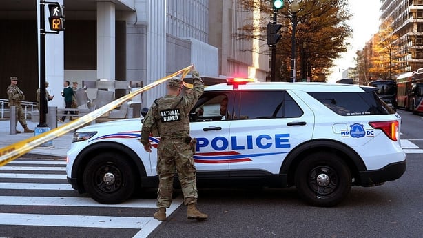 A member of the National Guard by a police car