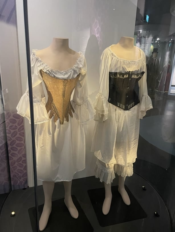 Two display models wearing corsets