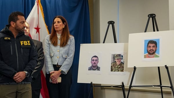 FBI Director Kash Patel looks at photos of the two West Virginia National Guard soldiers shot, along with the suspect