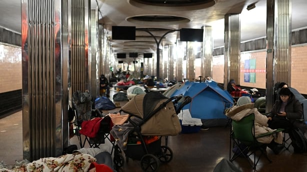 People take shelter at a metro station during an air attack in Kyiv