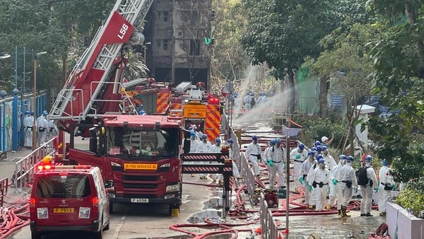 Police officers enter a burnt building