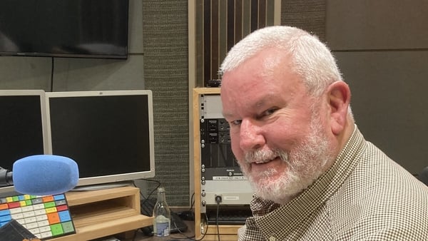 historian Las Fallon in RTÉ Radio studio, behind the mic, smiling sideways to camera, Nov 2025