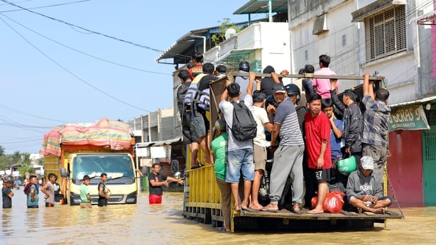 SUMATRA, INDONESIA - NOVEMBER 30: People use trucks to wade through a road in a flooded area on November 30, 2025 in Sumatra, Sumatra. The authorities in Indonesia were searching on Sunday for hundreds of people they said were missing after days of unusually heavy rains across Southeast Asia that ha