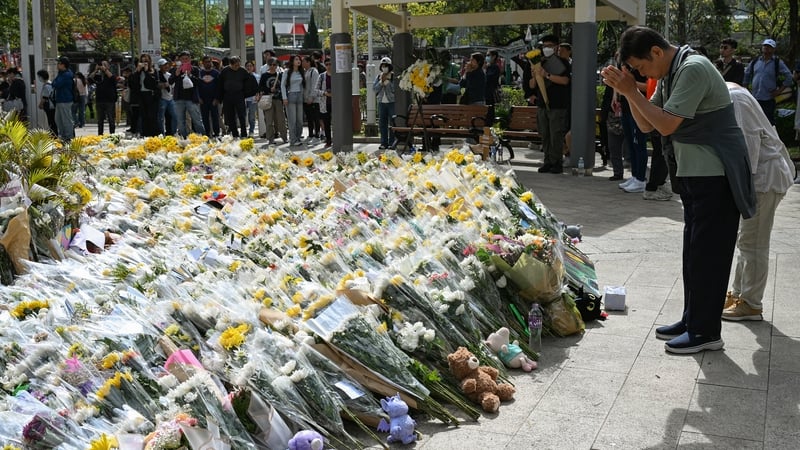 People leave flowers outside the Wang Fuk Court apartment blocks in the aftermath of the deadly fire in Hong Kong's Tai Po district