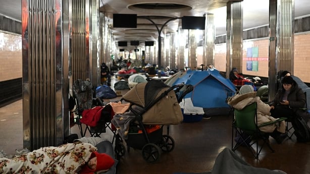 People take shelter at a metro station during an air attack in Kyiv