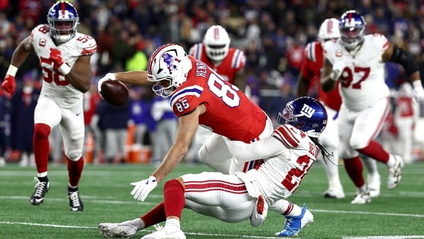 FOXBOROUGH, MASSACHUSETTS - DECEMBER 01: Hunter Henry #85 of the New England Patriots reaches for extra yards against Dane Belton #24 of the New York Giants during the fourth quarter of the game at Gillette Stadium on December 01, 2025 in Foxborough, Mass