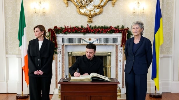 President Zelensky signs visitors book at Aras with President Catherine Connolly standing to his side