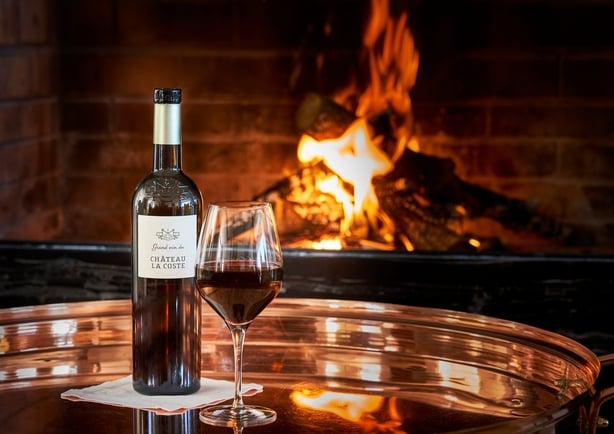 red wine by a fireplace