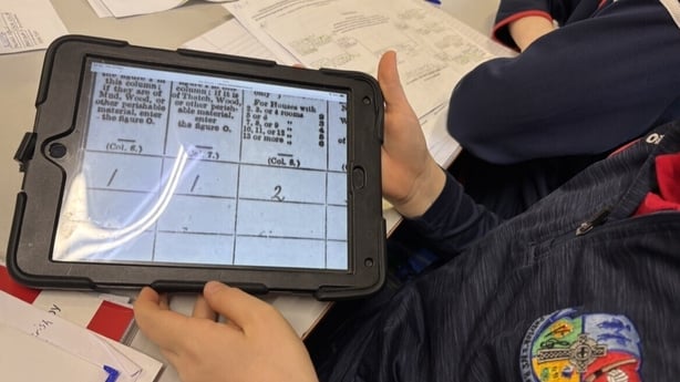A pupil looks at a census record on a tablet screen.