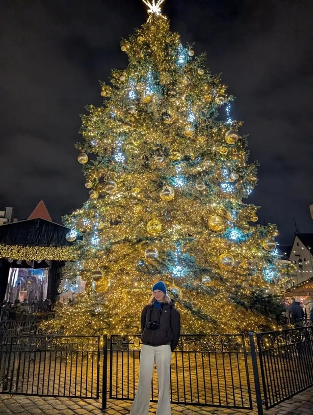 Rachael stands in front of the Christmas tree which has stood in Tallinn's Town Hall Square since 1441 (Rachael Davis/PA)