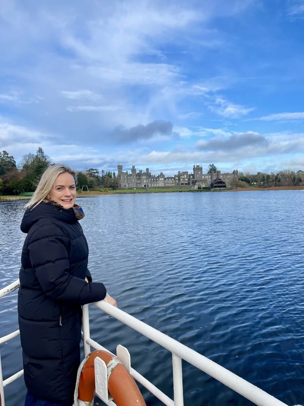 Deirdre Mullins on a boat in front of Ashford Castle