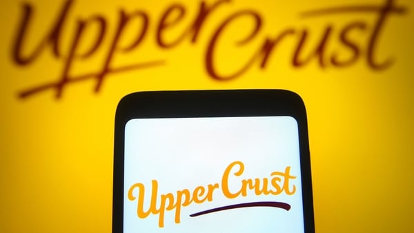 Upper Crust logo is displayed on a smartphone screen and on a yellow background