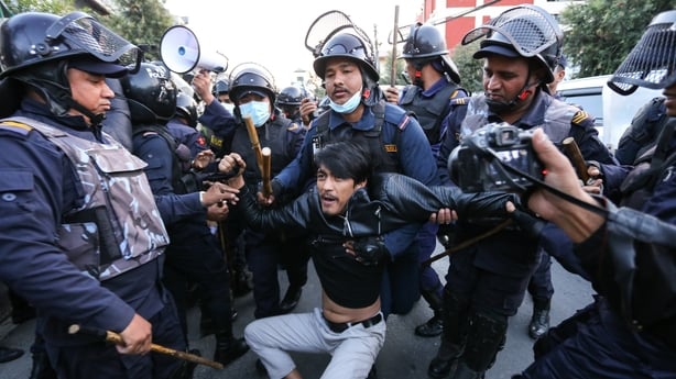 police officers carry a man away