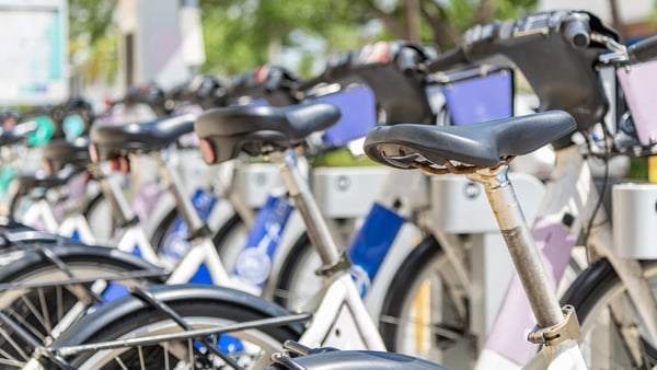 A group of electric bicycles for rent on a street corner in downtown Fort Lauderdale, Florida.