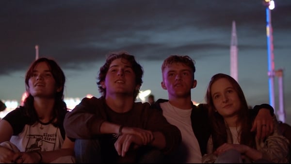 A still from Ivy Fiachra Cotter O'Culachain - four teens sit looking into the distance in a night scene