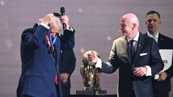 US President Donald Trump places a medal around his neck as he receives the FIFA Peace Prize from Italian Fifa President Gianni Infantino