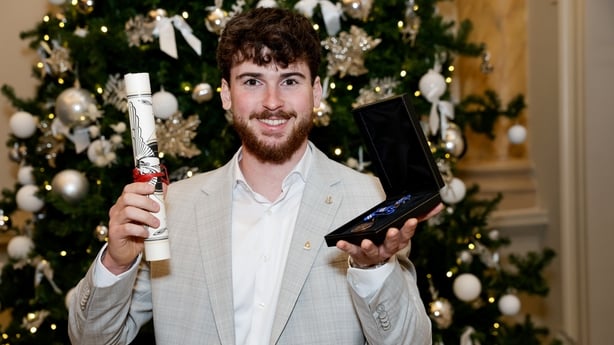 Jonathan Monroe holds up his awards.