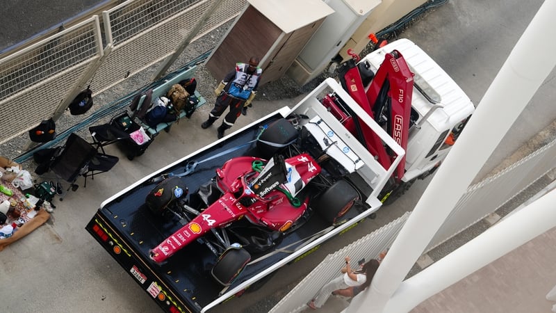 Lewis Hamilton's Ferrari is driven back to the garage after the crash